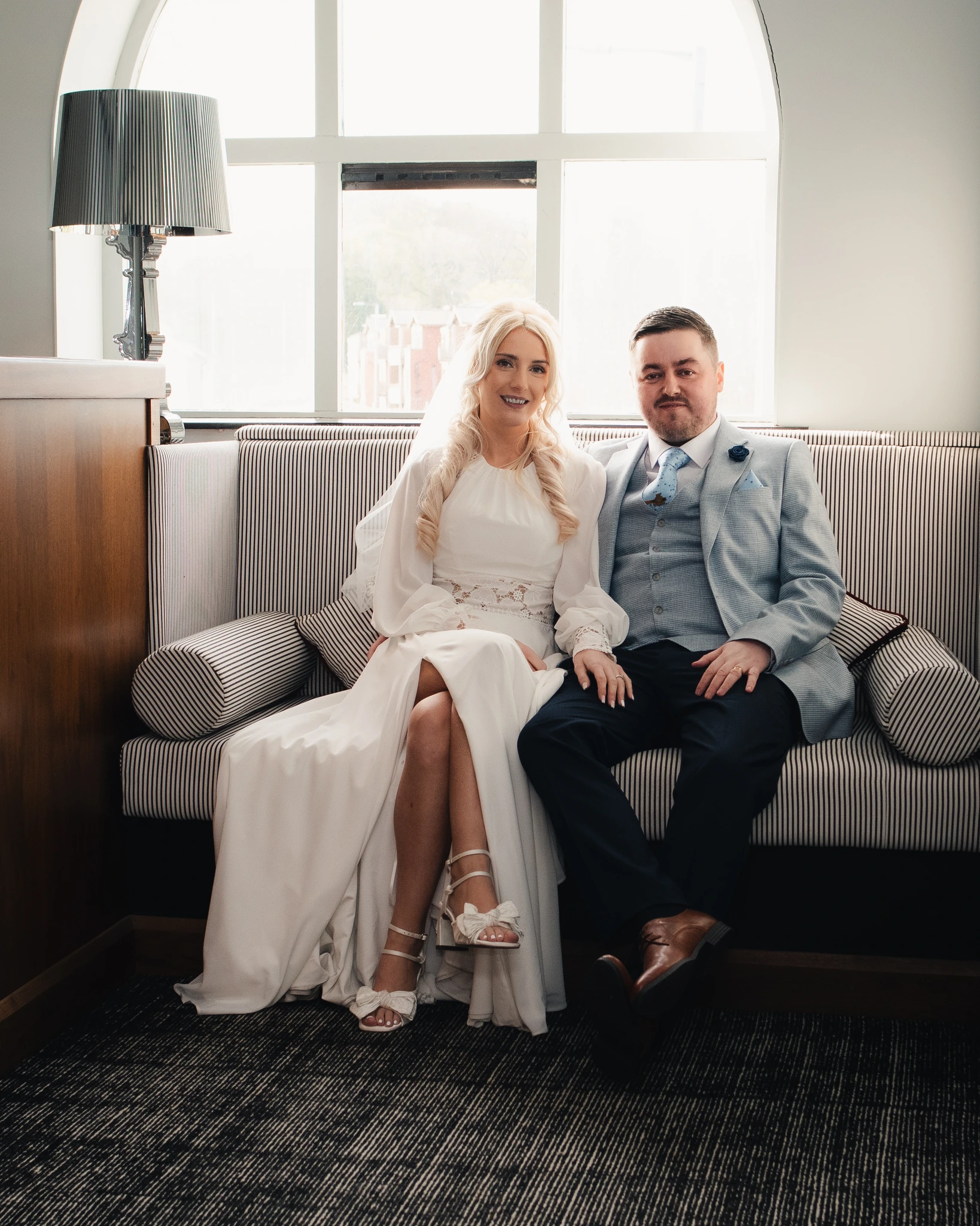 a bride and groom sitting on a sofa in a hotel room