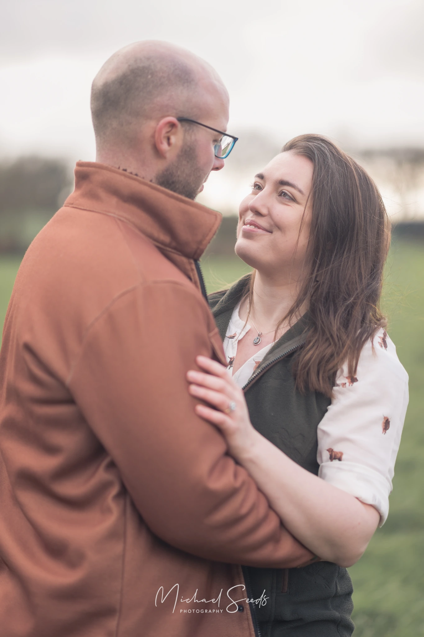 a couple hugging in a field during their engagement session