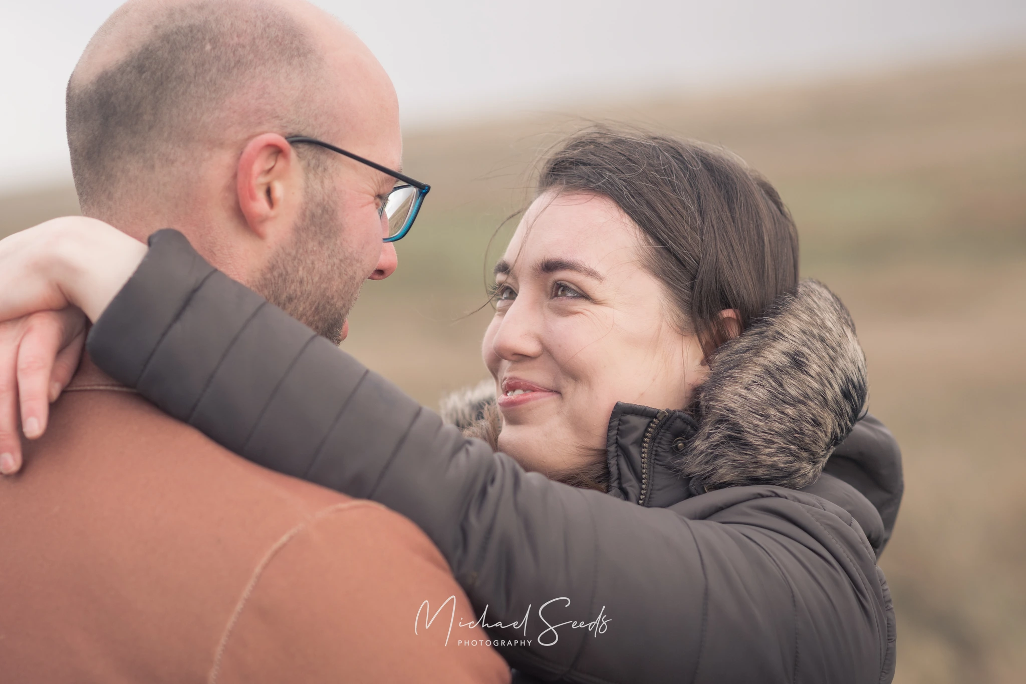 a man and woman hugging each other in a field