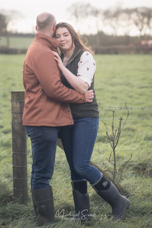 a man and woman hugging in a field
