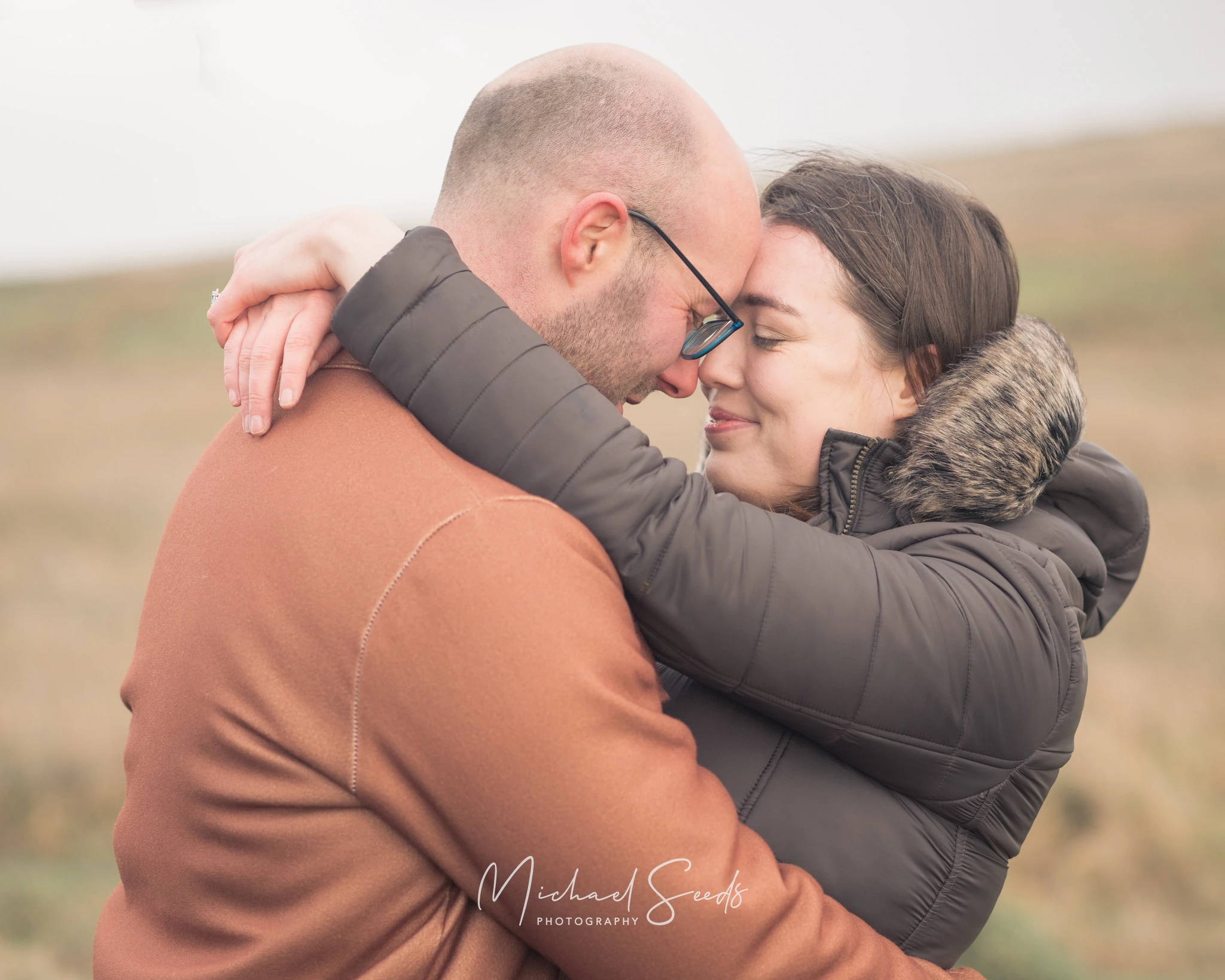 a man and woman hugging in a field