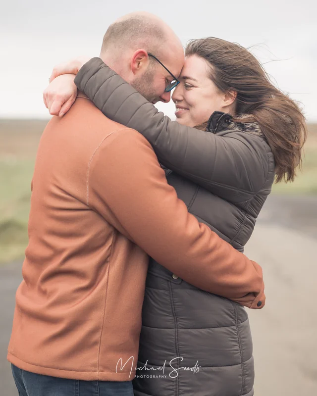 a couple hugging each other on a road in ireland