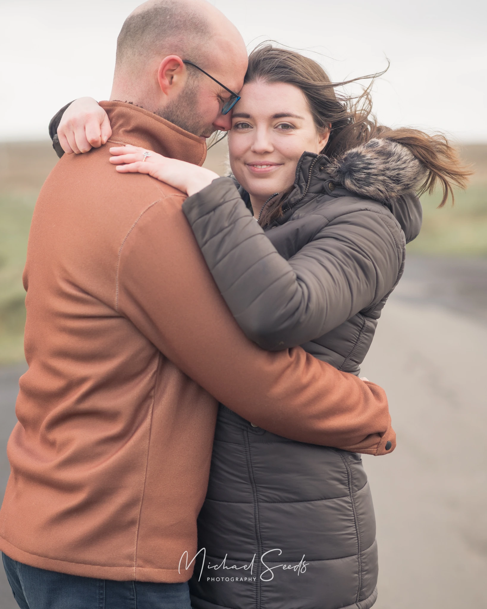 a man and woman hugging each other on a road