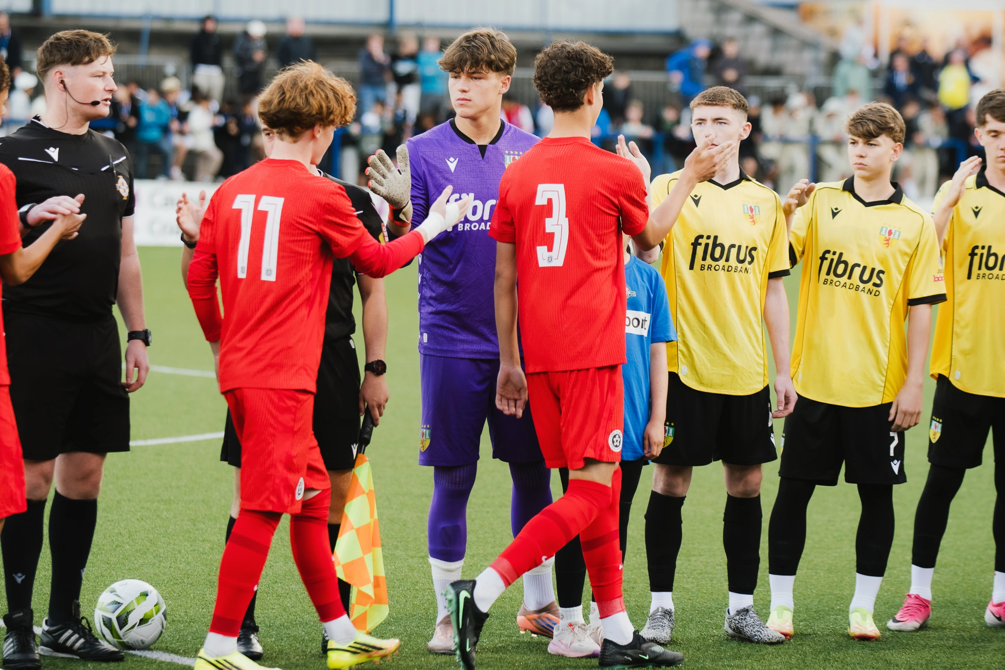 a group of soccer players standing in a circle on a field