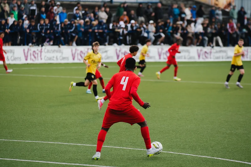 a soccer player kicks a ball in front of a crowd