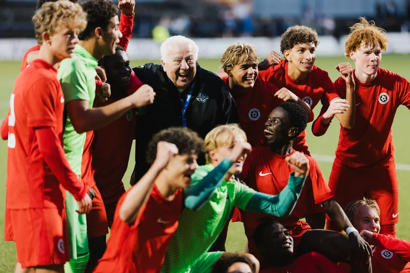 a soccer player celebrates with his team after winning a match