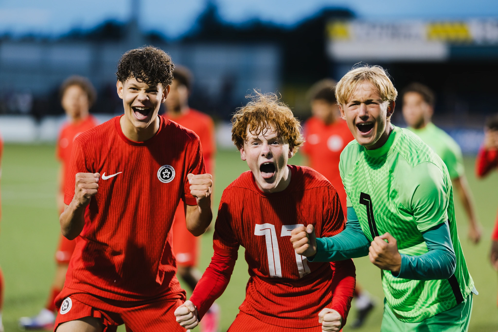 a group of soccer players celebrate after scoring a goal on the field