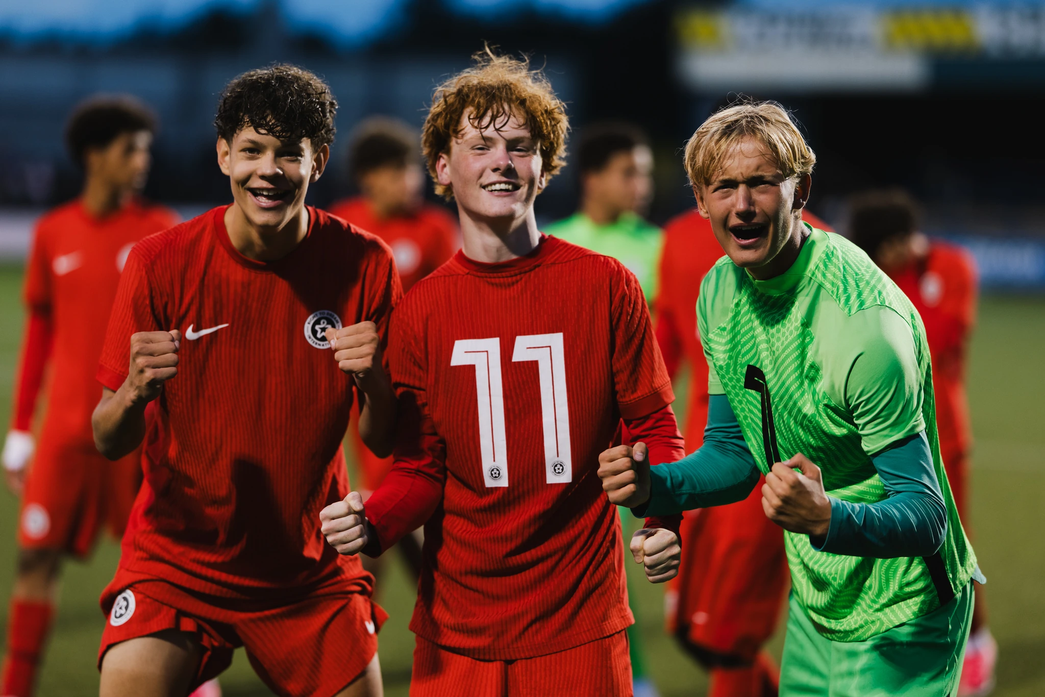 a group of soccer players celebrating after winning a game on the field