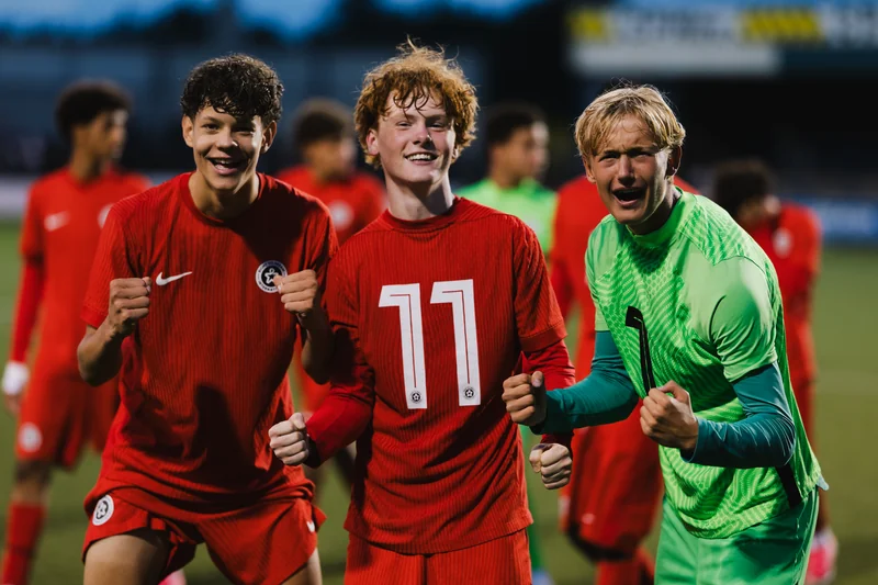a group of soccer players celebrating after winning a game on the field