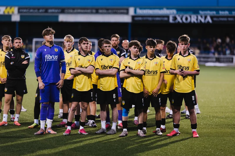 a group of young soccer players standing together on a pitch