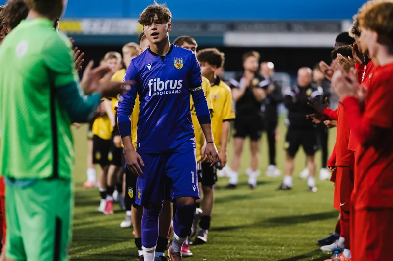a soccer player is greeted by his team mates before a match