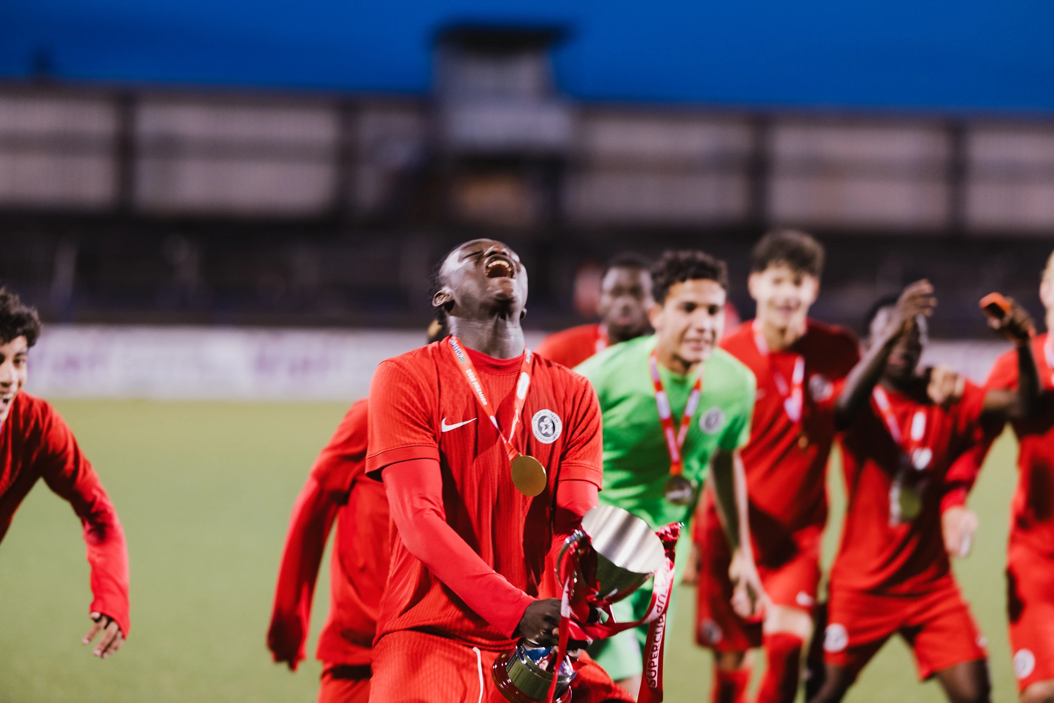 a group of soccer players celebrating after winning a match