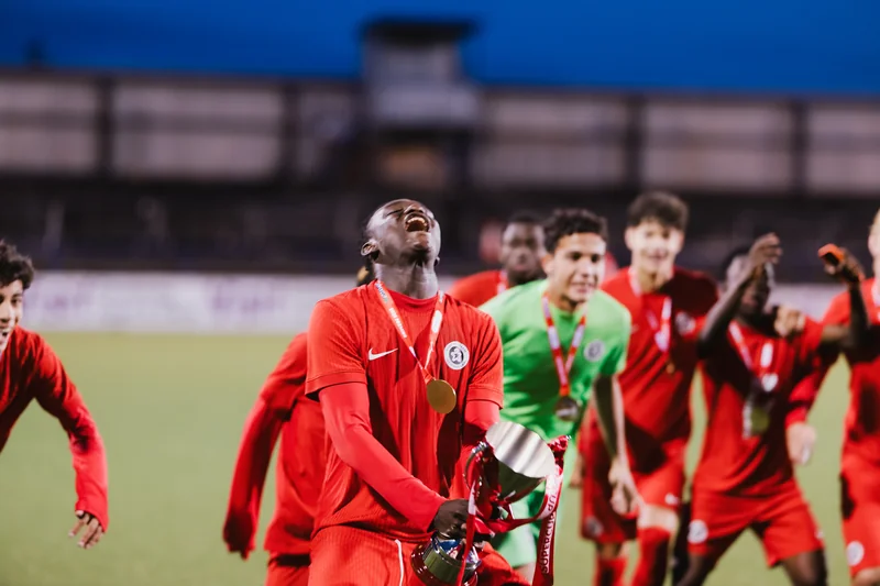 a group of soccer players celebrating after winning a match