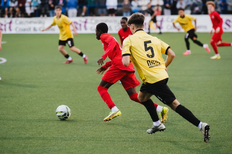 a group of men playing soccer on a field in front of a crowd