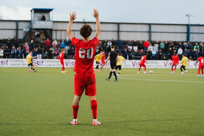 a soccer player celebrates a goal in front of a crowd