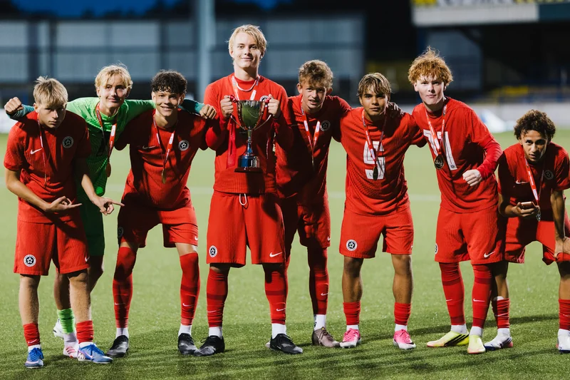 a group of soccer players standing together on a soccer field