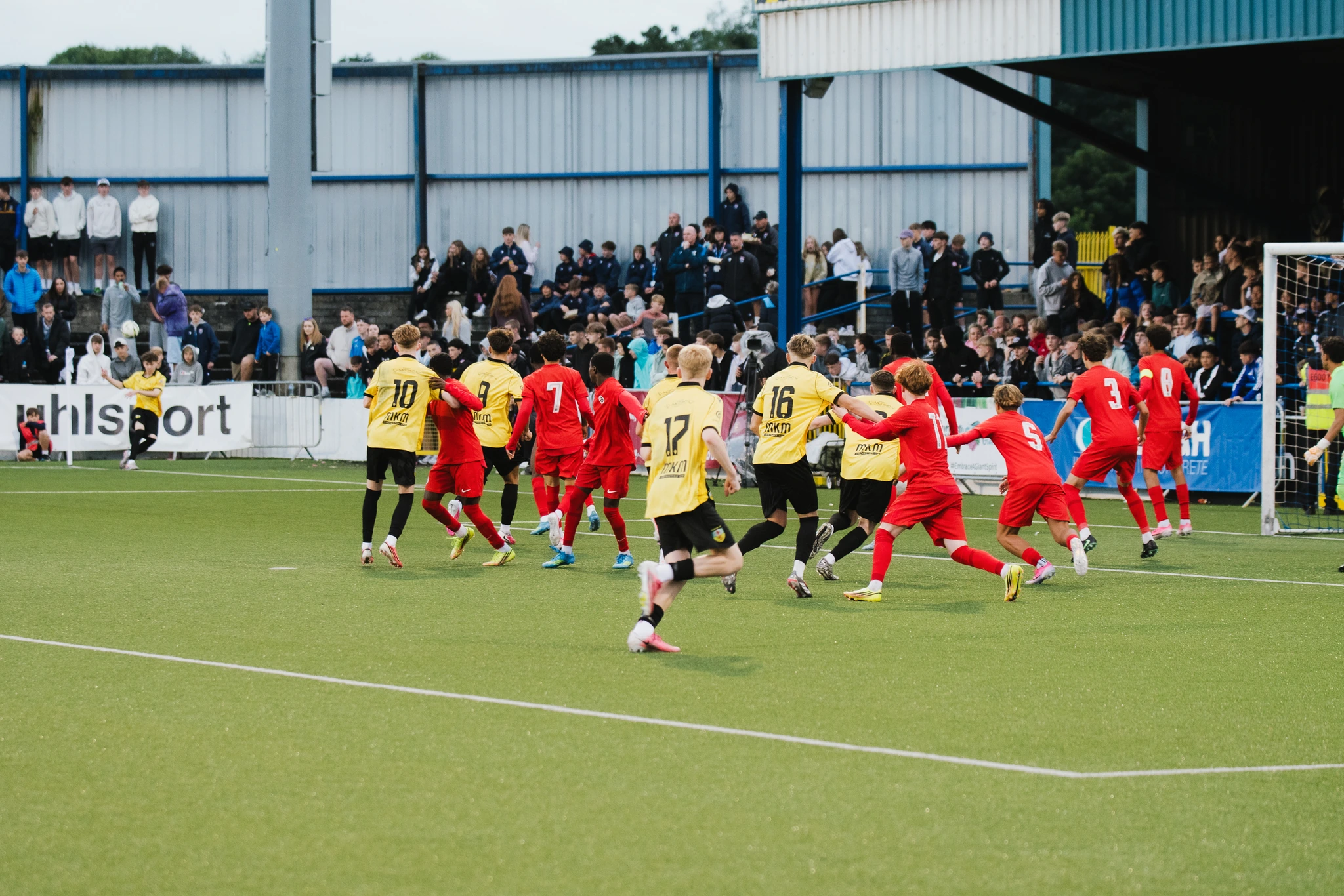 a group of soccer players celebrating a goal on a pitch