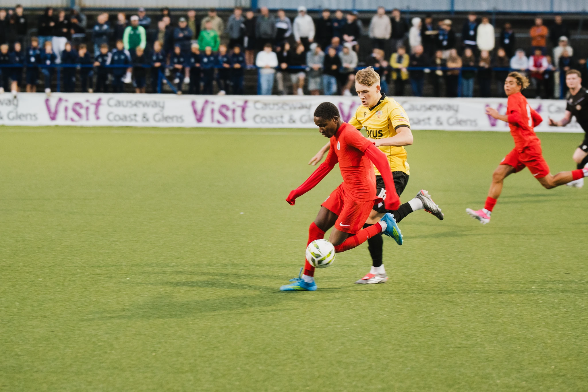 a group of men playing soccer on a field in front of a crowd