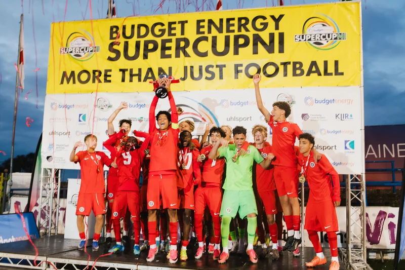 a group of soccer players standing on a banner with the words budget energy supercup