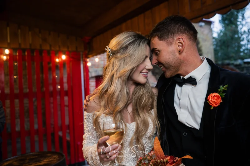 a bride and groom kiss in front of a red tent