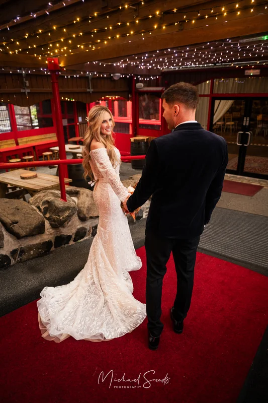 a bride and groom walk down a red carpeted aisle
