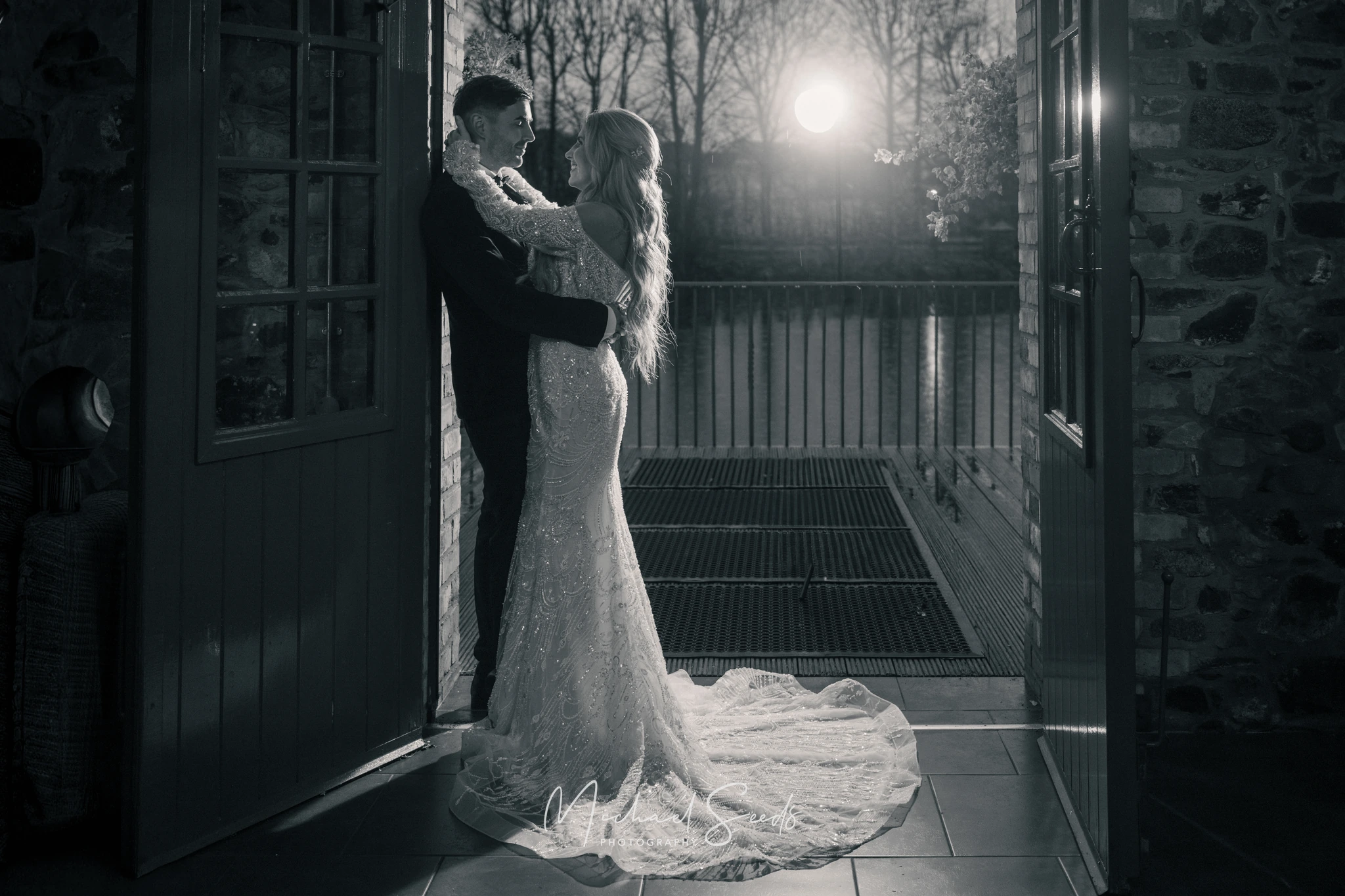 a bride and groom kiss in front of a barn door