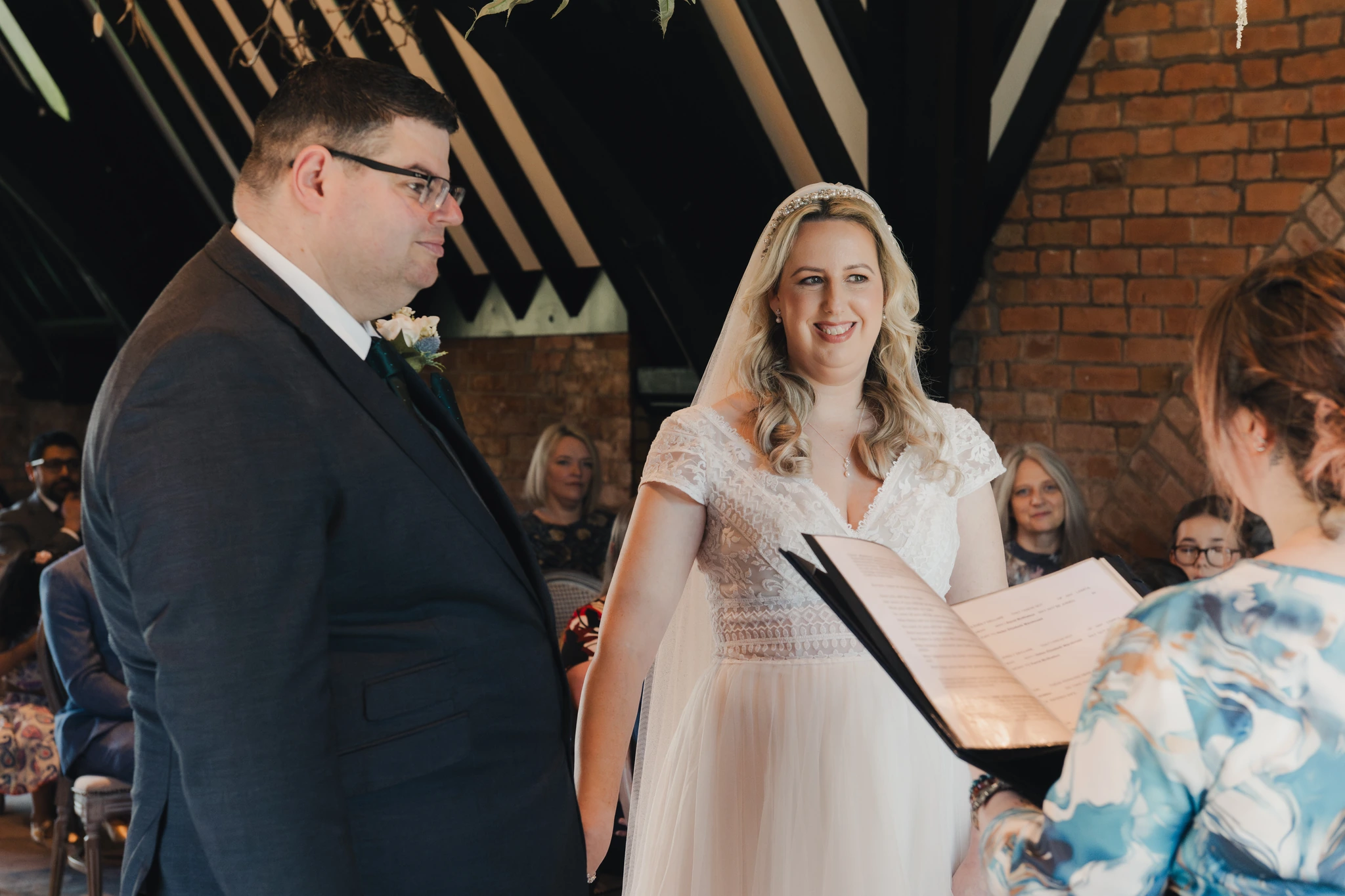 a bride and groom look at each other during their wedding ceremony