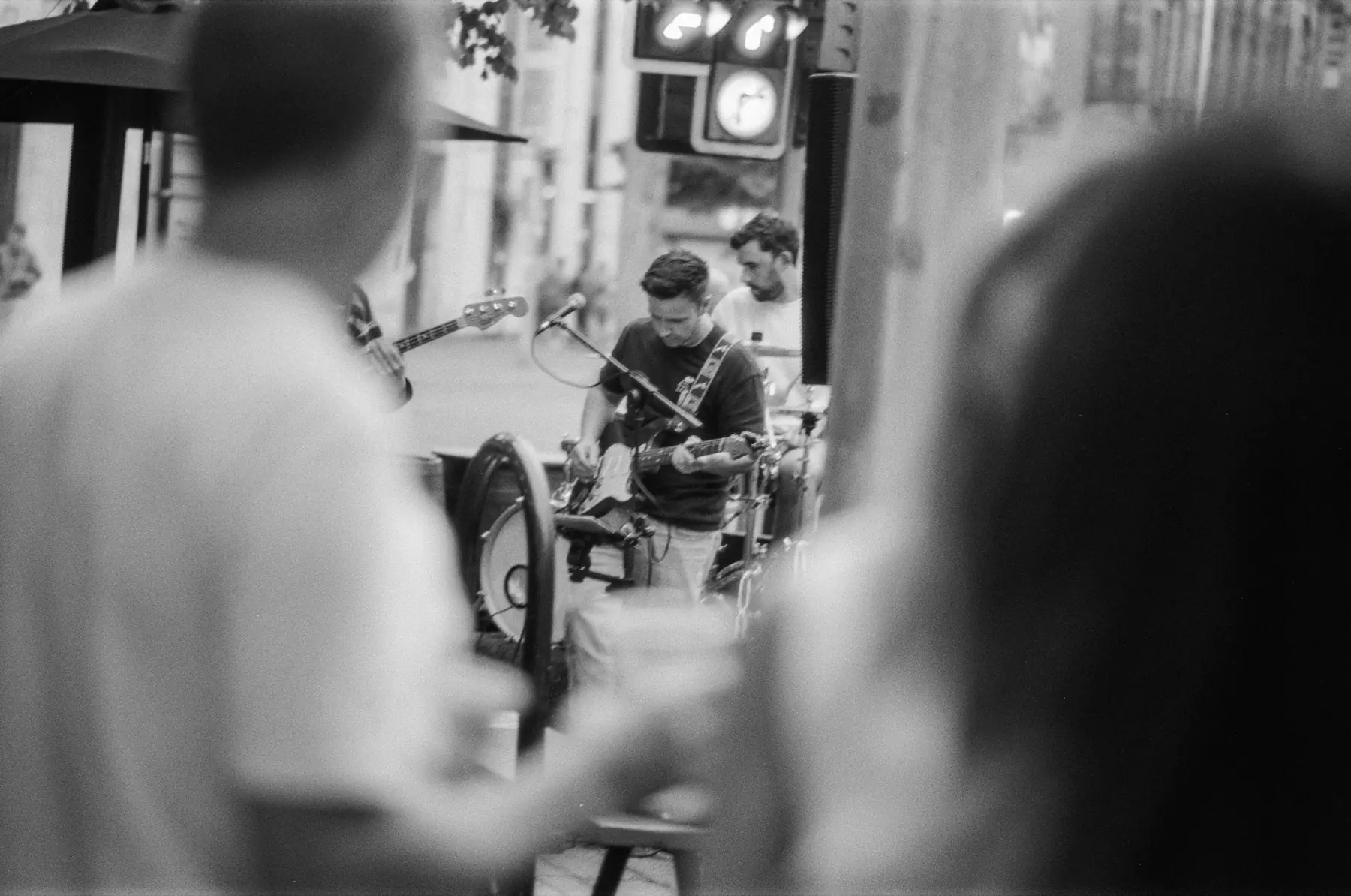 A musician seen through a layered crowd during a live street performance.